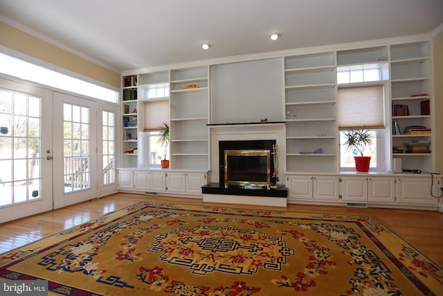 living room with light wood-type flooring, french doors, and crown molding