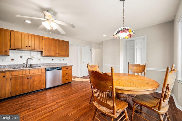 kitchen featuring dishwasher, sink, backsplash, hardwood / wood-style floors, and decorative light fixtures