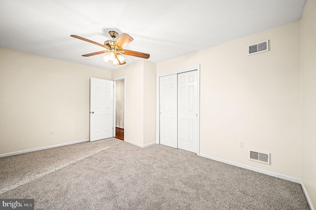 unfurnished bedroom with carpet, a closet, and ceiling fan