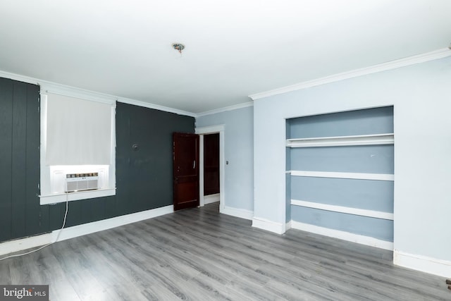 unfurnished bedroom featuring cooling unit, wood-type flooring, crown molding, and a closet