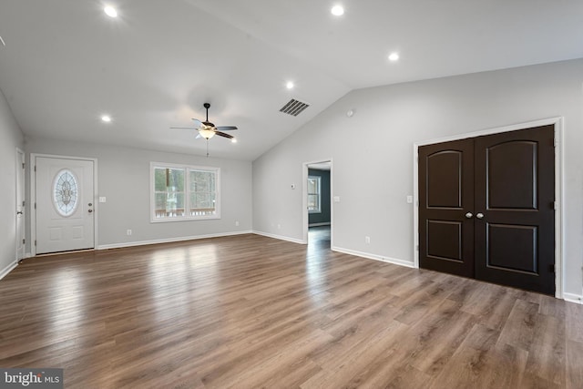 unfurnished living room featuring ceiling fan, wood-type flooring, and lofted ceiling