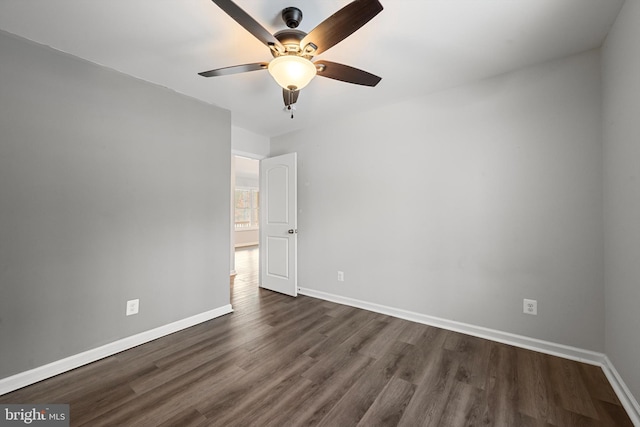 empty room with ceiling fan and dark hardwood / wood-style flooring