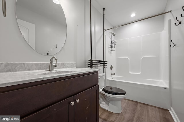 full bathroom featuring shower / washtub combination, hardwood / wood-style floors, vanity, and toilet