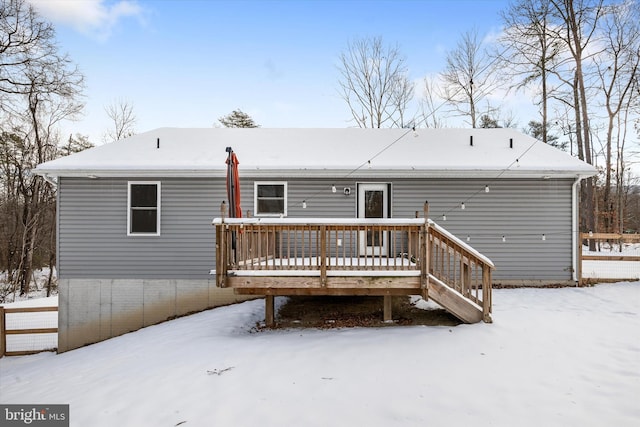 snow covered property with a deck