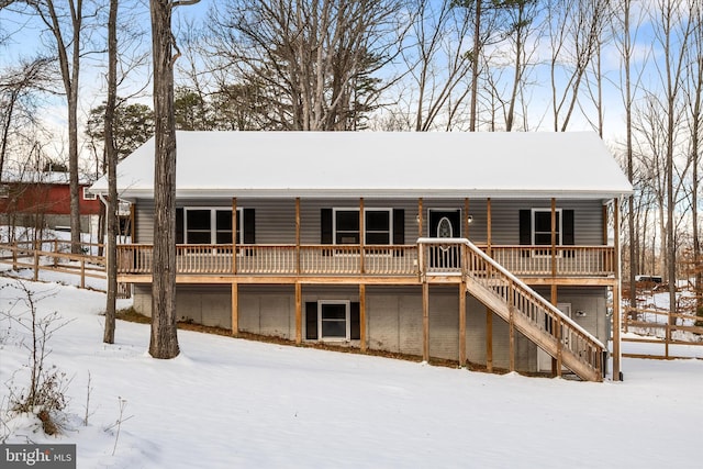 snow covered rear of property featuring a wooden deck