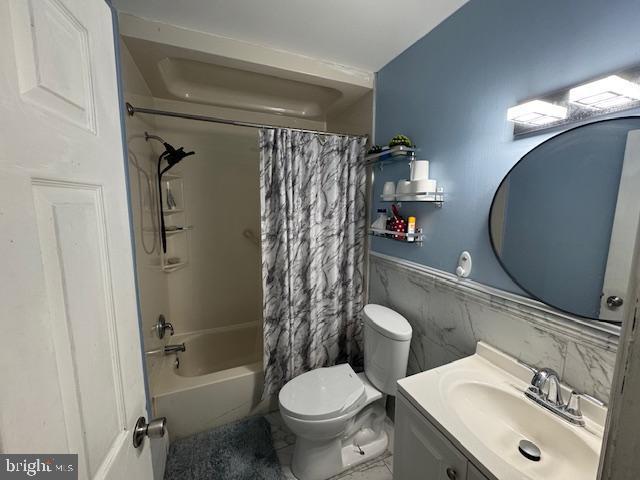 full bathroom with shower / tub combo with curtain, vanity, and toilet