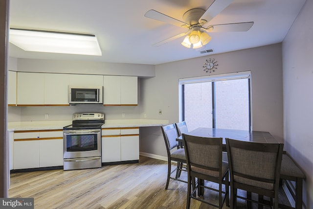 kitchen featuring ceiling fan, light hardwood / wood-style flooring, white cabinets, and appliances with stainless steel finishes