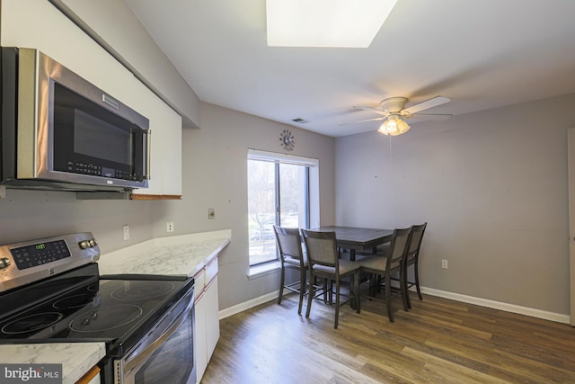 kitchen with ceiling fan, dark hardwood / wood-style floors, and stainless steel appliances