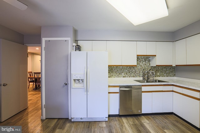 kitchen featuring white fridge with ice dispenser, sink, stainless steel dishwasher, backsplash, and white cabinets