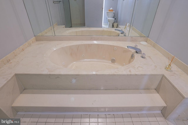 bathroom with tile patterned flooring, toilet, and a tub