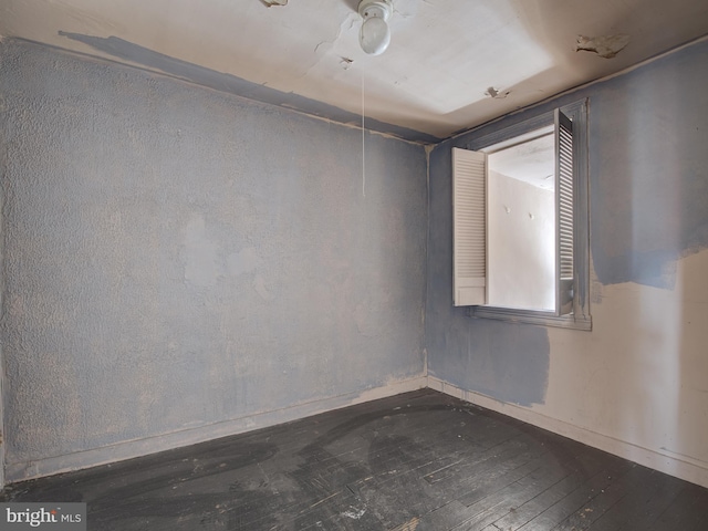 unfurnished room with ceiling fan and dark wood-type flooring