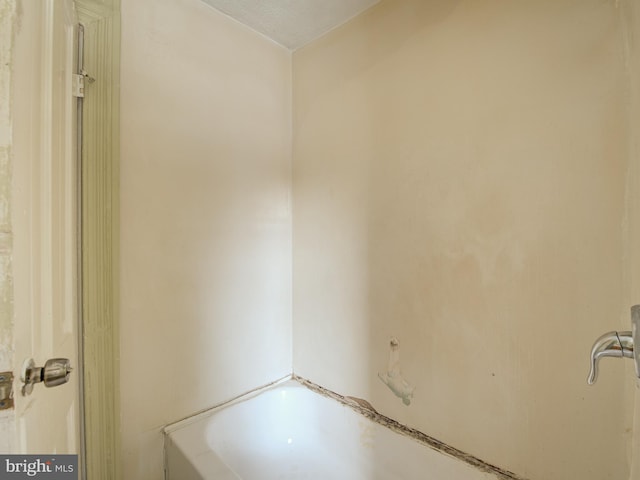 bathroom with a bath and a textured ceiling