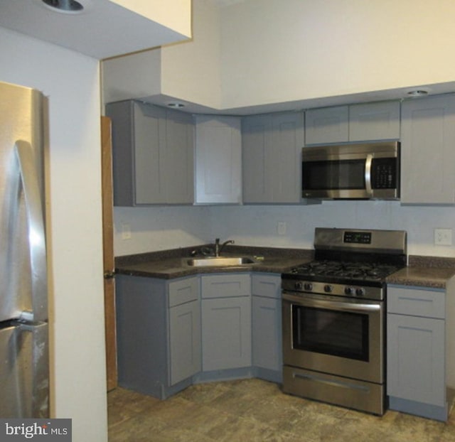 kitchen with gray cabinetry, sink, and appliances with stainless steel finishes