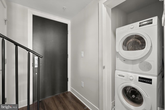 clothes washing area with dark hardwood / wood-style floors and stacked washer / drying machine