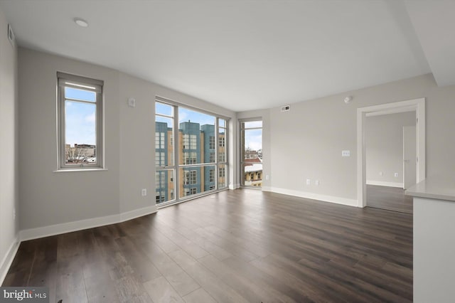 unfurnished room with dark wood-type flooring