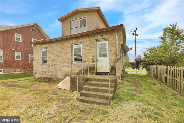 rear view of house featuring a yard