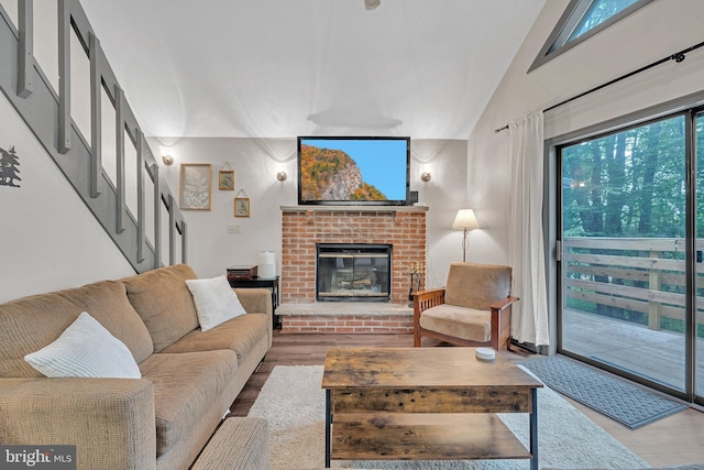 living room with light wood-type flooring, lofted ceiling, and a fireplace