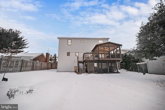 snow covered rear of property with a deck