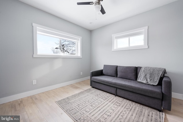 living room with plenty of natural light, light hardwood / wood-style floors, and ceiling fan