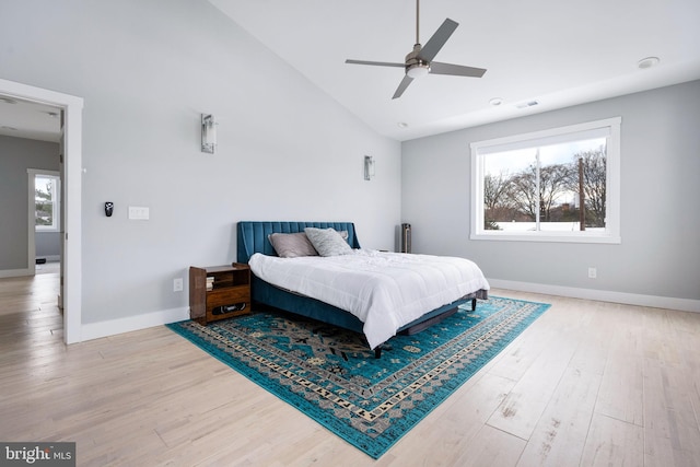 bedroom featuring hardwood / wood-style flooring, ceiling fan, and high vaulted ceiling