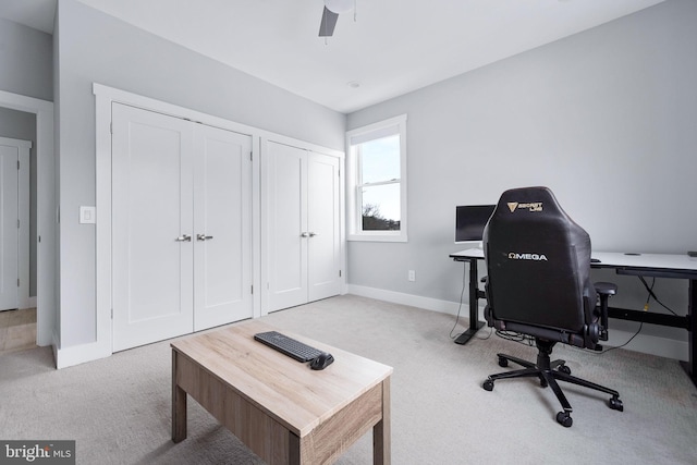 carpeted home office featuring ceiling fan