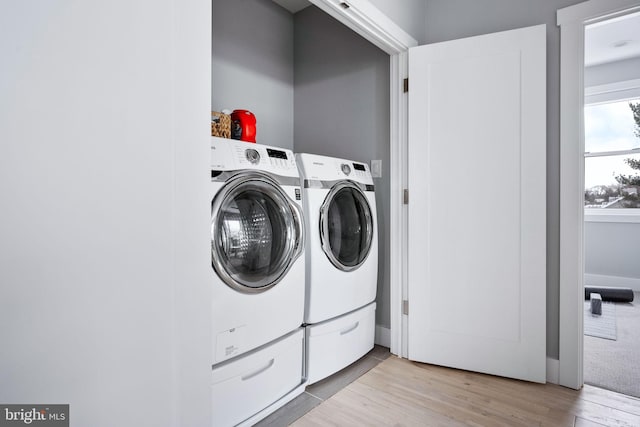 washroom with separate washer and dryer and light hardwood / wood-style floors