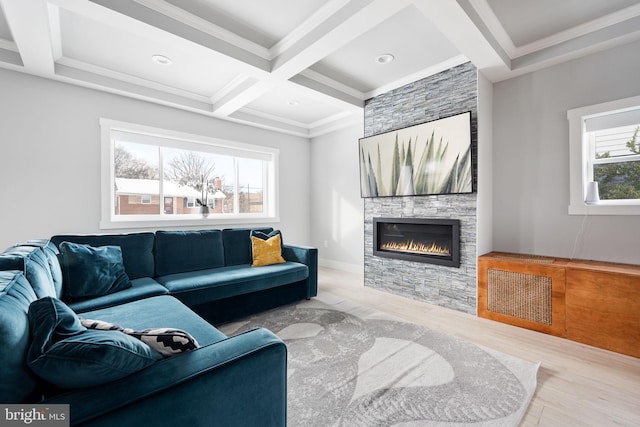 living room featuring coffered ceiling, a stone fireplace, crown molding, beamed ceiling, and light hardwood / wood-style floors