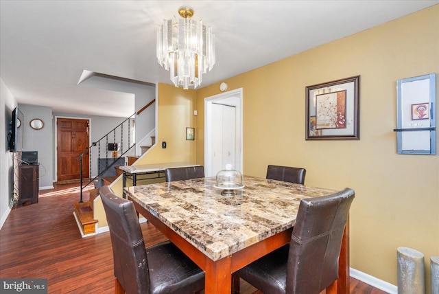 dining space with dark hardwood / wood-style flooring and a chandelier