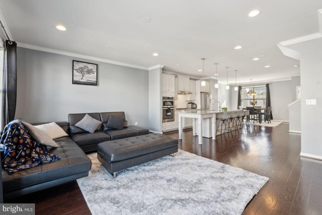 living room featuring sink, dark wood-type flooring, and ornamental molding