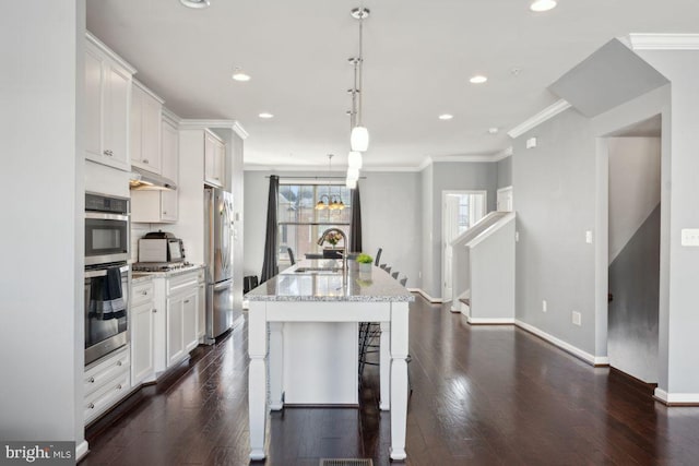 kitchen featuring a center island with sink, white cabinets, stainless steel appliances, and sink