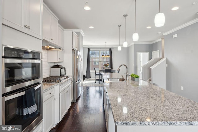 kitchen featuring a spacious island, white cabinetry, sink, and stainless steel appliances