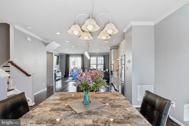 dining room with dark hardwood / wood-style flooring, an inviting chandelier, and crown molding