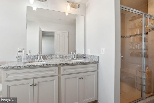 bathroom featuring vanity, toilet, and a shower with shower door