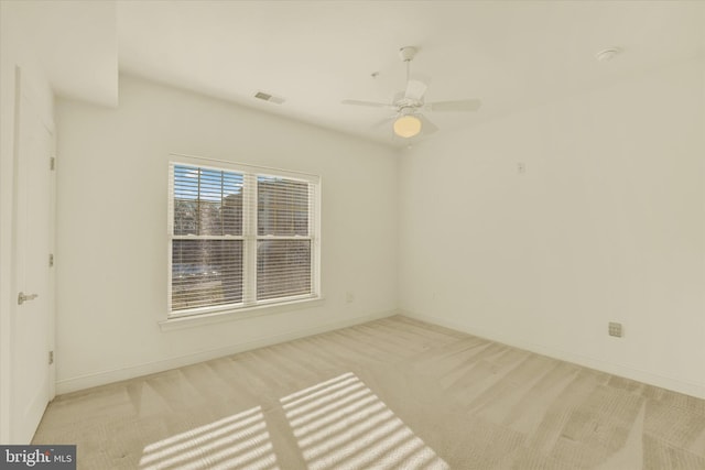 spare room with ceiling fan and light carpet