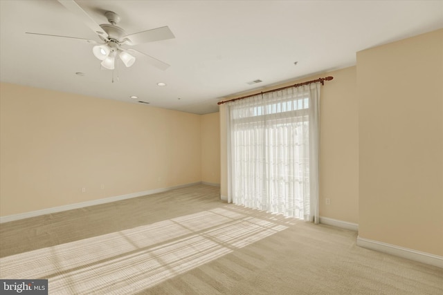 spare room with ceiling fan and light carpet