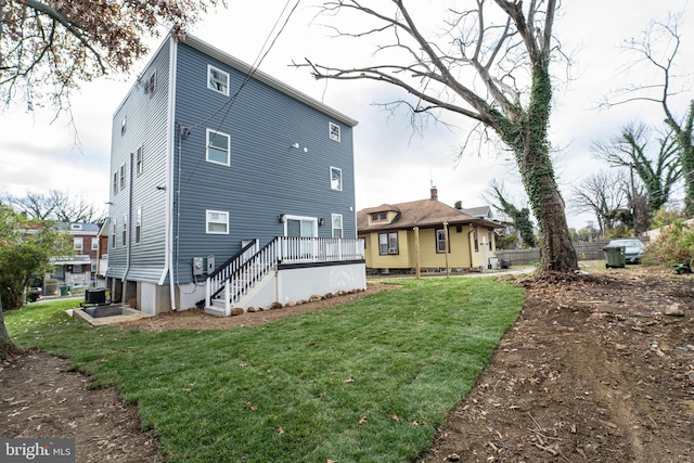 rear view of house with a wooden deck, a yard, and cooling unit