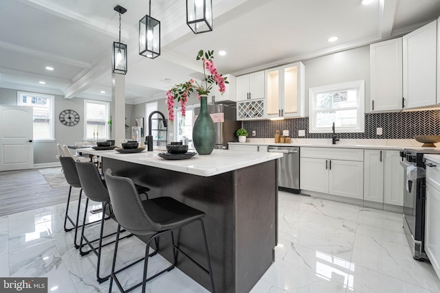 kitchen featuring white cabinets, a kitchen island with sink, and appliances with stainless steel finishes