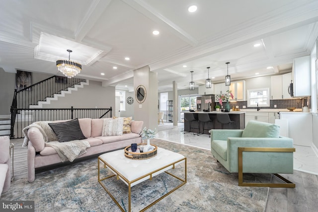 living room featuring beam ceiling, crown molding, and a chandelier