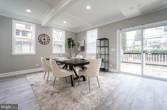 dining space featuring plenty of natural light, beam ceiling, light wood-type flooring, and crown molding