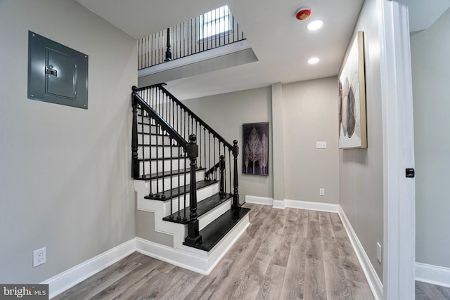 staircase featuring hardwood / wood-style floors and electric panel