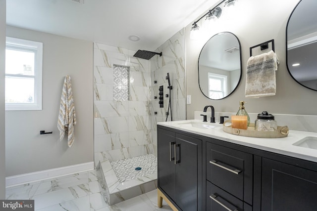 bathroom with tiled shower and vanity