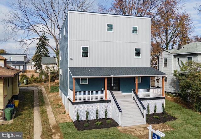 view of front of house with covered porch and a front lawn