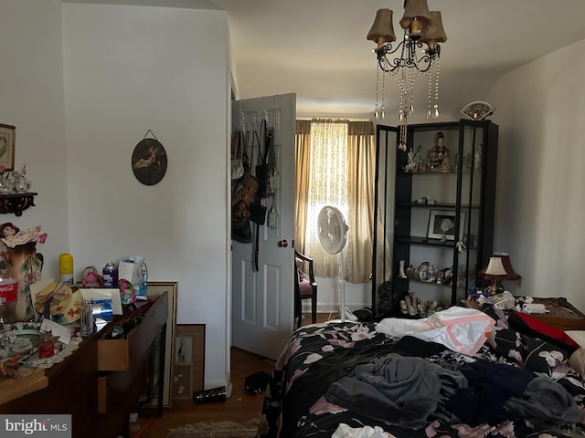 bedroom with hardwood / wood-style flooring and a notable chandelier