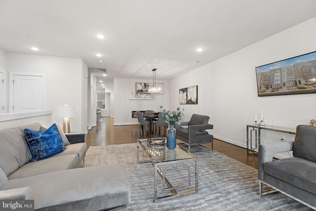 living room with dark hardwood / wood-style flooring and a notable chandelier