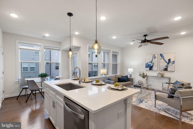 kitchen with sink, hanging light fixtures, white cabinets, a center island with sink, and stainless steel dishwasher