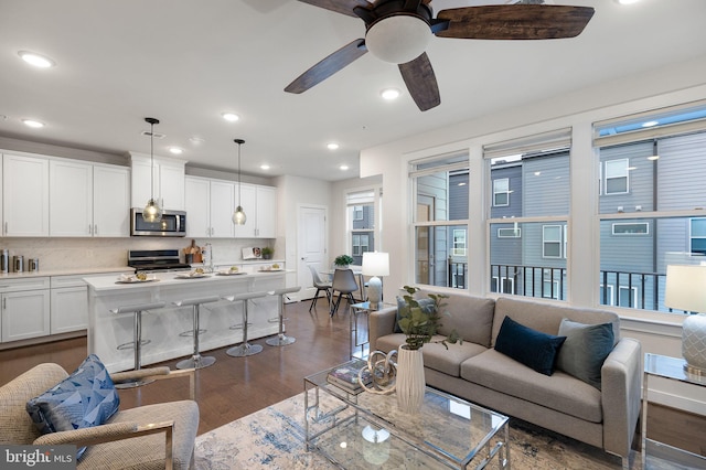 living room with dark hardwood / wood-style floors and ceiling fan