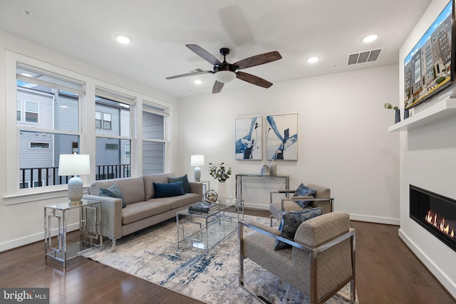 living room with dark hardwood / wood-style floors and ceiling fan