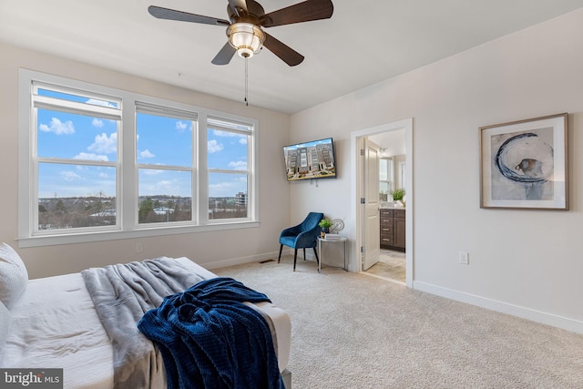 bedroom featuring ceiling fan, ensuite bathroom, and light colored carpet