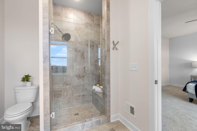 bathroom with a shower with door and toilet