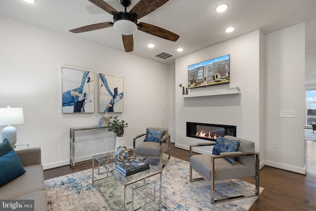 living room with dark hardwood / wood-style flooring and ceiling fan